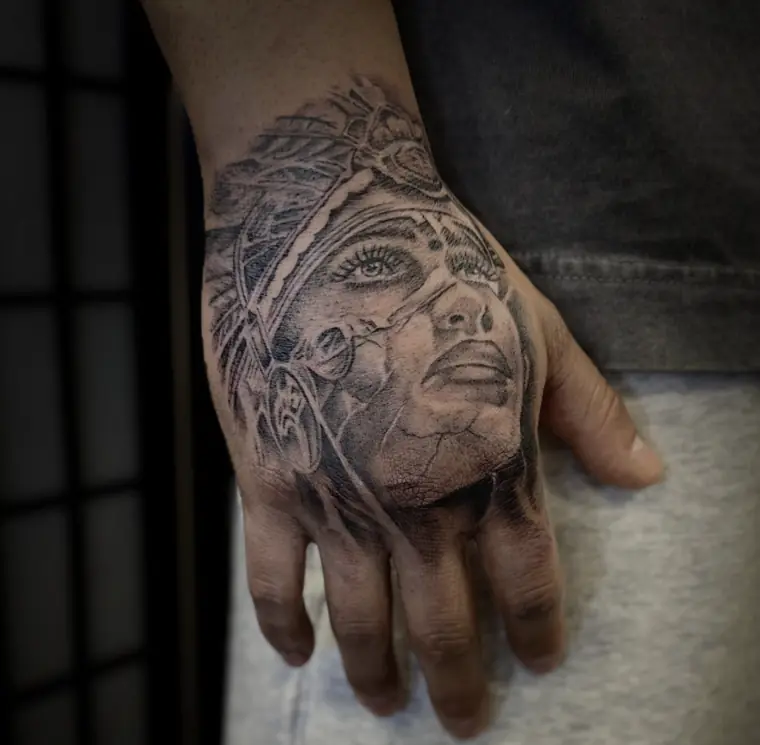 A woman’s face in a feathered headdress, realism across the back of a hand.